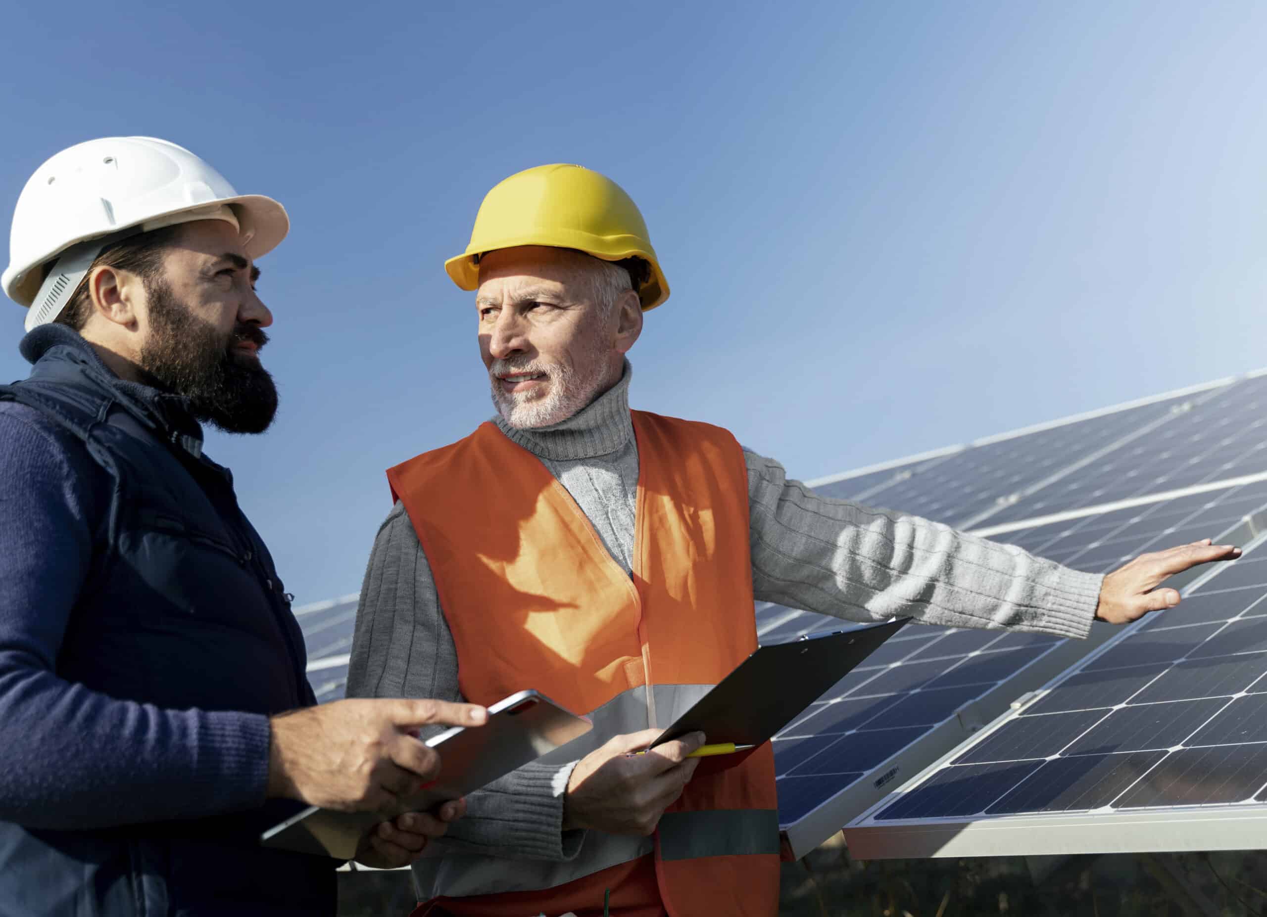 Kaksi miestä tutkivat aurinkovoimalaa.