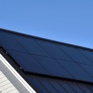 Aurinkovoimala avaimet käteen. Kiiltävät mustat aurinkopaneelit asennettuna tummalle katolle, aurinkopaneelien mikroinvertterijärjestelmä.