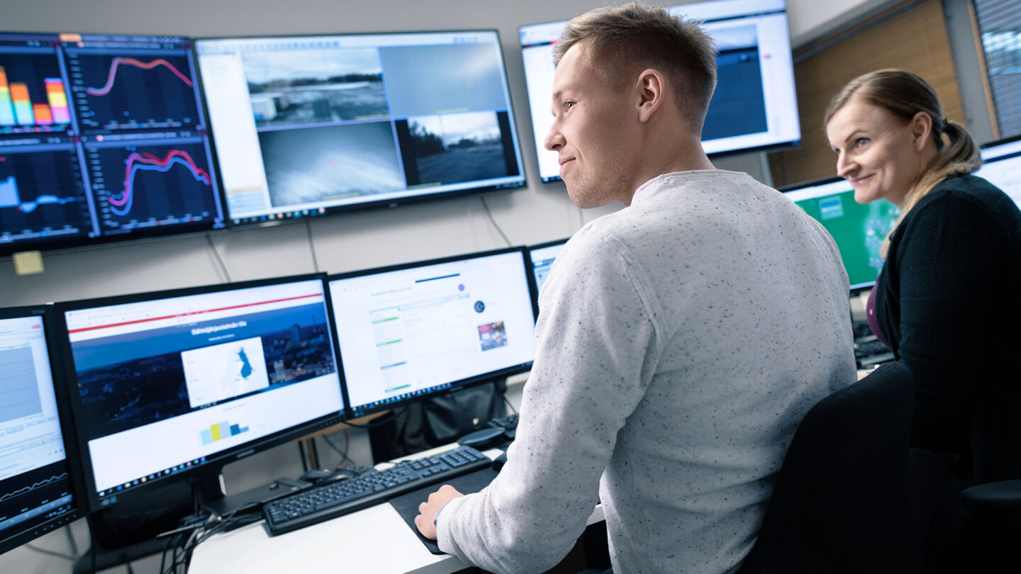 Ihmiset työskentelevät tietokoneilla energia valvontahuoneessa.